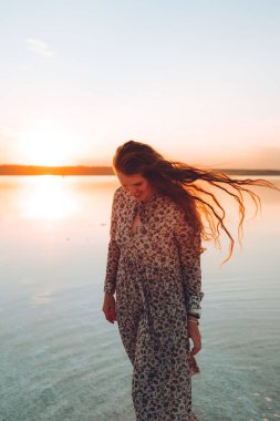 Pembe elbiseli mutlu kadın portresi tuzlu pembe gölün çöl sahilinde eğleniyor. Ukrayna tuz gölü