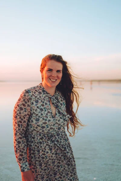 Pembe elbiseli mutlu kadın portresi tuzlu pembe gölün çöl sahilinde eğleniyor. Ukrayna tuz gölü