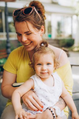 Mutlu anne ve kız dışarıda birlikte gülüyorlar.