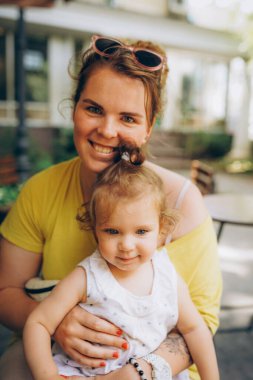 Mutlu anne ve kız dışarıda birlikte gülüyorlar.