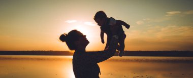 Anne ve oğlu kumsalda gün batımının tadını çıkarıyor..