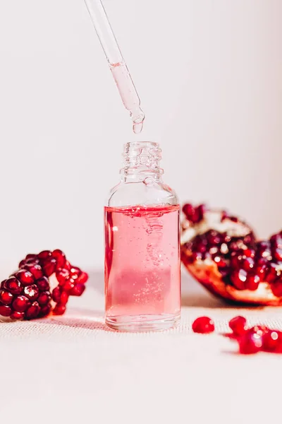 Pomegranate oil in a cosmetic bottle with a pipette. Natural cosmetics and face care.