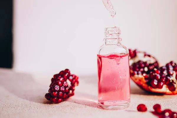 Pomegranate oil in a cosmetic bottle with a pipette. Natural cosmetics and face care.