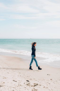 Young cheerful woman enjoing sunny day on the beach.