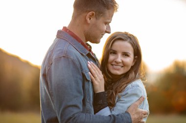 Happy partners on a getaway kissing, smiling and relaxing outdoors enjoying and loving the sunlight