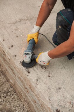 Hands of man with glove using electric steel cutter machine while working