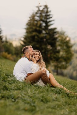 Young couple deeply in love laughing and cuddling, enjoying the time spent in nature.