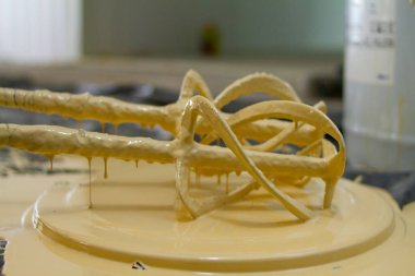 Karıştırıcının kürekleri epoksi reçineyle kaplıdır ve damlaları ve dökülmeleri önlemek için kovanın kapağına konmuştur..