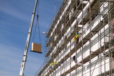 Endüstriyel inşaat alanı metal iskeleler ve ağır maddeleri daha yüksek seviyelere taşımak için kullanılan bir vinçle donatılmıştır.. 