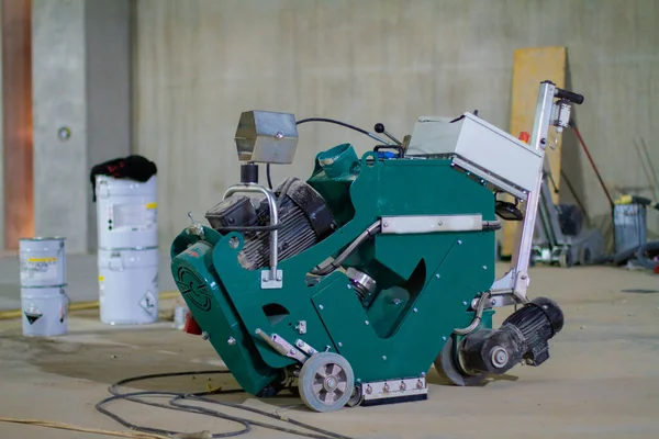 An industrial machine equipped with diamond discs is used to grind concrete floors to a smooth and even finish, preparing the surface for the application of new coatings.