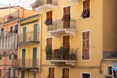 İtalya 'nın 5 Terre bölgesindeki Manarola kentindeki zarif balkonları ve süslü bitkileriyle güzel renkli binaların etkileyici manzarası. Kompozisyon, geleneksel İtalyan mimarisini mükemmel bir şekilde yakalıyor. 