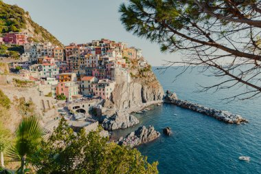 Manarola, İtalya 'nın bir kıyı kasabası, deniz manzaralı dik yamaçlar boyunca uzanan renkli evleri gözler önüne seriyor, önlerinde küçük bir liman ve kayıklar, ve ufka doğru uzanan mavi sular.