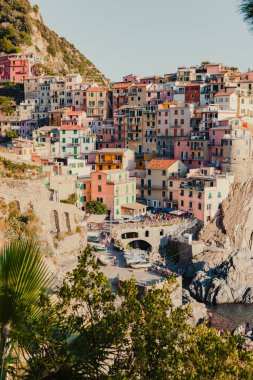 Manarola, İtalya 'nın bir kıyı kasabası, deniz manzaralı dik yamaçlar boyunca uzanan renkli evleri gözler önüne seriyor, önlerinde küçük bir liman ve kayıklar, ve ufka doğru uzanan mavi sular.
