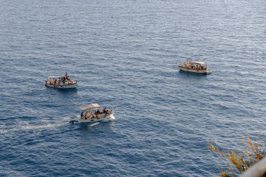 Mavi denizdeki 5 Terre köyünü ziyaret eden turistli küçük tekneler. Tekneler sakin sularda yüzerken görülebilir.,