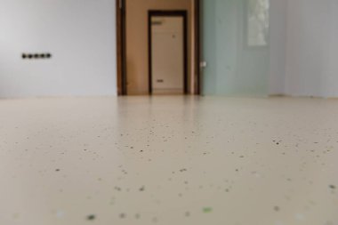 Yeni dekoratif epoksi döşemeleri olan bir tıbbi tesis. Kusursuz yüzeyde gömülü renkli çipler canlı ve dayanıklı bir çözüm yaratır. Seçici odak