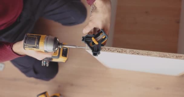 Ein Erfahrener Mann Montiert Möbel Hause Mit Einem Leistungsstarken Akku — Stockvideo