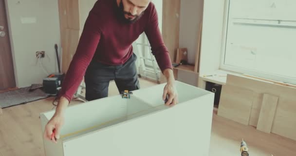 熟練した男がテープで測定し 彼が構築している家具の上に鉛筆でマーク 作業時の精度と細部への注意 — ストック動画