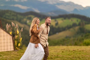 Çiftler koşar, güler, gelin damadın sırtına atlar, derin bir sevgi gösterir, arkasında dağlar olur..