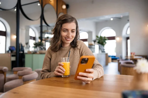 Mükemmel bir ara: ferahlatıcı bir portakal suyu ve bu kadın için eğlenceli telefon videoları.