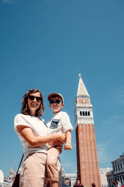 Bir anne ve 4 yaşındaki oğlu, Venedik 'in ana meydanında çekilen samimi bir anı yakaladılar. Aralarındaki bağ, İtalya 'nın ikonik şehrinin güzelliği arasında sevgi ve ailenin özünü somutlaştırarak mercekten yayılıyor.