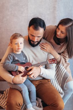 Parıldayan ışıklarla süslenmiş sıcacık bir Noel ortamında genç bir aile neşeyle bir araya gelir..