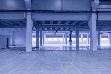 Pencereleri olan boş bir fabrikanın içinde.