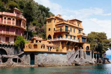 Güneşli bir yaz gününde İtalya 'da Portofino sahilinde renkli evler duruyor.