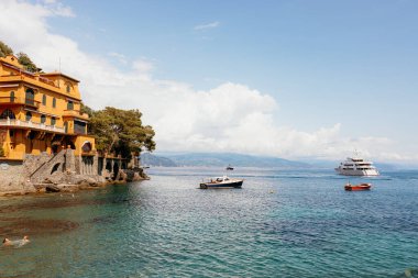 Portofino, İtalya 'da güneşli bir günde lüks bir villanın önünde gemiler yelken açıyor.