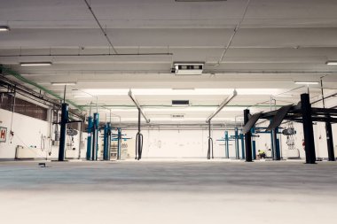 Boş modern araba servisi atölyesi. Hidrolik asansörleri ve parlak epoksi zemini var.