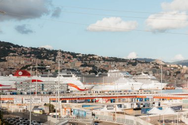 Büyük yolcu gemileri, arkalarında şehir manzarası yükselen Ceneviz, İtalya 'nın hareketli limanına demirledi.