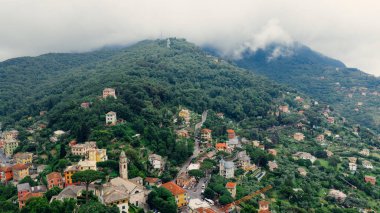 İtalyan Riviera kıyı şeridine kurulmuş büyüleyici bir köy olan Camogli 'nin hava manzarası, yemyeşil dağlardan gelen sisle birlikte
