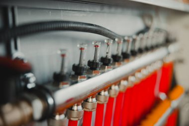 Bir alt kattaki ısıtma sisteminde su basıncını düzenleyen akış sayaçları olan bir manifoldun yakınlaştırılması, verimli bir sıcaklık denetimi sağlar