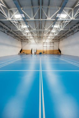 Kurulum sürecinde mavi epoksi tabanlı ve beyaz çizgili boş spor salonu