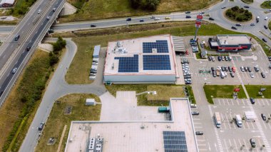 Sürdürülebilir enerji üretimi için çatı güneş panellerini kullanan modern endüstriyel yapı, karbon ayak izini azaltmak ve temiz enerji çözümlerini desteklemek