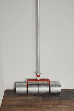 Kurulum sırasında yeni vinil döşeme üzerinde duran üç tekerlekli zemin presi