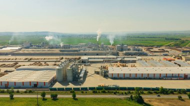 Duman yayan bir ahşap işleme fabrikasının hava görüntüsü, endüstriyel faaliyetlerin çevresel etkisini vurguluyor