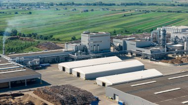 Yenilenebilir enerji üretimi için ahşap atıkları kullanan bir biyokütle enerji santralinin hava görüntüsü, kırsal alanda sürdürülebilir uygulamalar sergiliyor