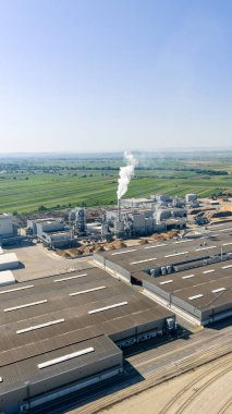 Duman yayan bir biyokütle enerji santralinin hava görüntüsü, kırsal alanda yenilenebilir enerji üretimini vurguluyor