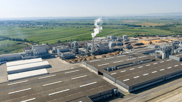 Aerial view of a modern wood processing plant emitting smoke, highlighting industrial manufacturing processes and environmental impact
