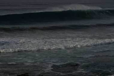 Dalgalar kayalık bir kıyıda breaking