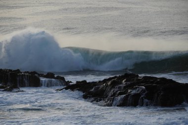 Büyük dalga kayalara çarpıyor.