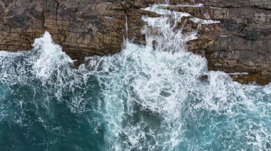 Dalgalar kayalara çarpıyor.