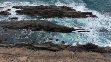 Dalgalar kayalara çarpıyor.