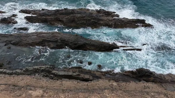 Dalgalar kayalara çarpıyor.