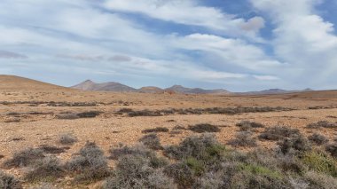 Bulutlu bir gökyüzü ile kuru tepelerin yüksek açılı görüntüsü.