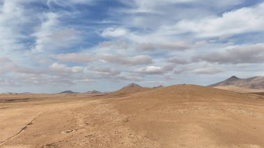 Dağları ve bulutlu gökyüzü olan güzel bir manzara.