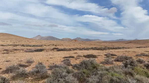 Bulutlu bir gökyüzü ile kuru tepelerin yüksek açılı görüntüsü.