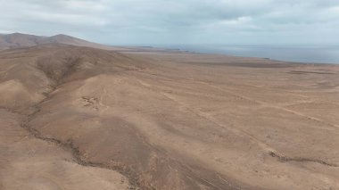 Dağların havadan görünüşü ve arka planda bir çöl