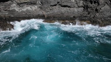 Okyanus dalgaları kayalık kıyılarda kırılıyor