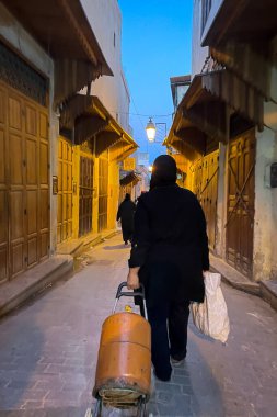 Fez Medine 'sinde, Müslüman bir kadın yemek pişirme gazı silindiri çekiyor.